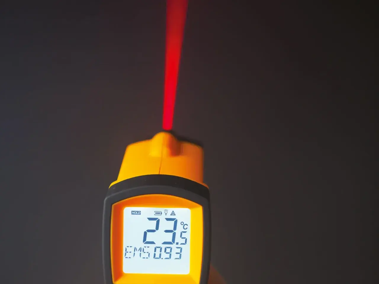 Żółty pirometr z czerwonym laserem i wyświetlaczem pokazującym 23.5°C.