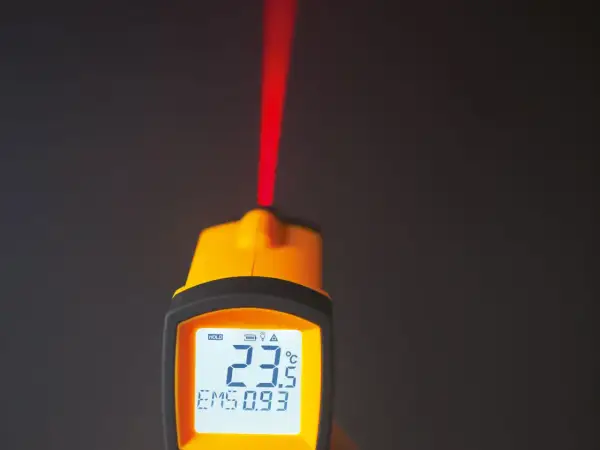 Żółty pirometr z czerwonym laserem i wyświetlaczem pokazującym 23.5°C.